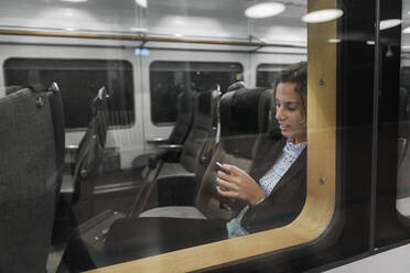 Frau benutzt Smartphone im Zug - FOLF10669