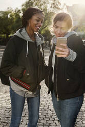 Mädchen im Teenageralter benutzen ein Smartphone - FOLF10679