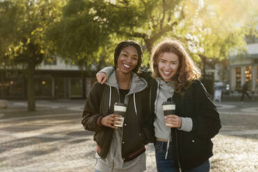 Lächelnde Teenager-Mädchen mit Kaffeetassen - FOLF10684