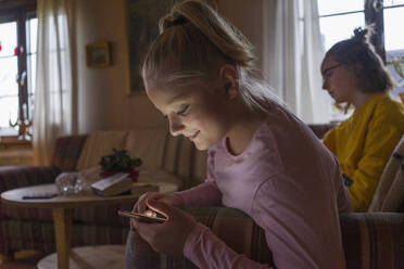 Teenage girl looking at cellphone indoors - FOLF10689