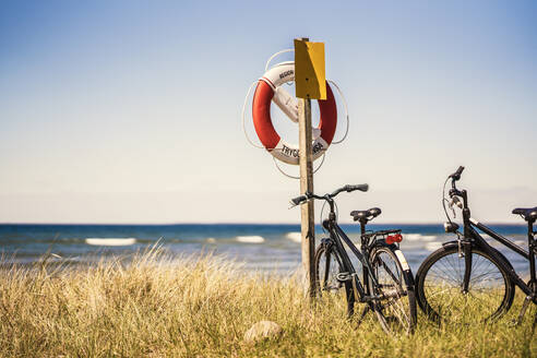 Fahrräder neben einer Rettungsweste am Strand - FOLF10710