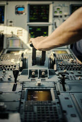 Hand des Piloten auf dem Bedienfeld des Flugzeugs - FOLF10712