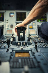 Hand des Piloten auf dem Bedienfeld des Flugzeugs - FOLF10713