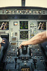 Hand des Piloten auf dem Bedienfeld des Flugzeugs - FOLF10714