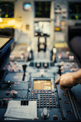 Hand des Piloten auf dem Bedienfeld des Flugzeugs - FOLF10715