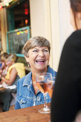 Ältere Frau lachend in Bar - FOLF10749