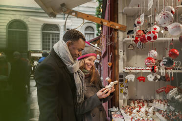 Ehepaar kauft auf dem Weihnachtsmarkt ein - FOLF10770