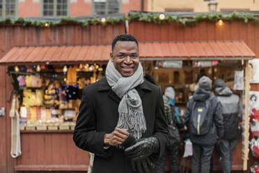 Porträt eines lächelnden jungen Mannes auf dem Markt - FOLF10778