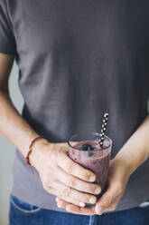 Man holding healthy glass of smoothie - MOMF00763