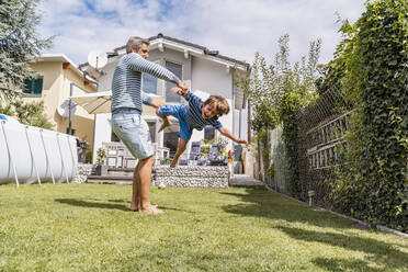 Vater spielt mit Sohn im Garten - DIGF08173