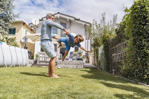 Father playing with son in garden - DIGF08173