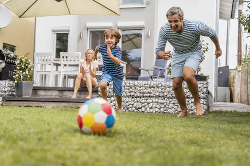 Vater und Sohn spielen Fußball im Garten - DIGF08242