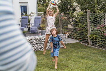 Glückliche Familie spielt Fußball im Garten - DIGF08246