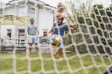 Happy family playing football in garden - DIGF08248