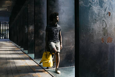 Mann mit gelbem Rucksack schaut in die Ferne, Barcelona, Spanien - JRFF03695