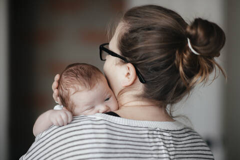 Portrait of a young woman with a baby at home stock photo