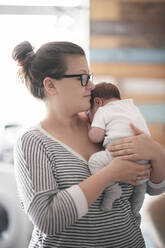 Porträt einer jungen Frau mit einem Baby zu Hause - EYAF00467
