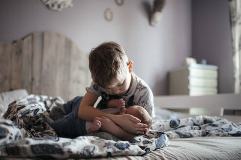 Older boy with his baby brother in the bedroom - EYAF00470