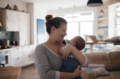 Porträt einer jungen Frau mit einem Baby zu Hause - EYAF00472