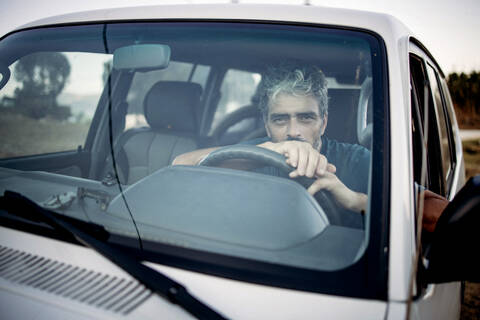 Älterer Mann sitzt in seinem Geländewagen, lizenzfreies Stockfoto