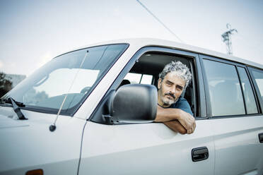 Mature man sitting in his off-road vehicle - OCMF00649