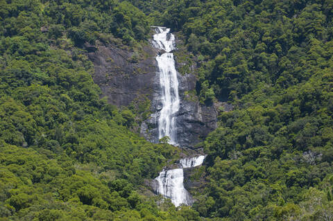 Blick auf einen Wasserfall auf einem Berg inmitten von Bäumen, Grande Terre, Neukaledonien, lizenzfreies Stockfoto