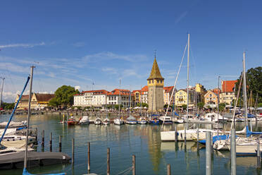 Boote im Hafen mit Gebäuden im Hintergrund vor blauem Himmel, Lindau, Deutschland - LHF00686