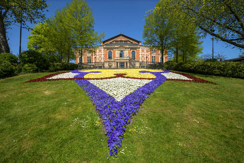 Bunte Blumen wachsen vor dem Bayreuther Festspielhaus gegen den klaren Himmel an einem sonnigen Tag, Bayreuth, Deutschland - LBF02707