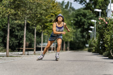 Lächelnde junge Frau auf Inline-Skates - STSF02236
