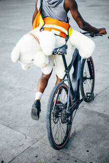 Fahrradkurier liefert einen Teddybär aus - OCMF00676