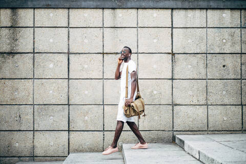 Young man on the phone walking in the city stock photo