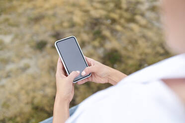 Nahaufnahme einer Frau, die im Freien ein Smartphone benutzt - BSZF01446