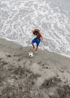 Junge spielt Fußball am Strand - LJF00977