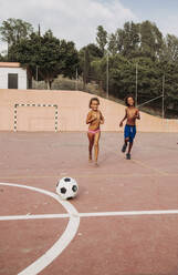 Two children playing soccer on a soccer field - LJF00982