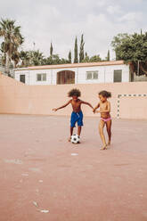 Two children playing soccer on a soccer field - LJF00983