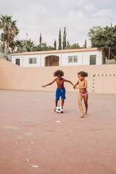 Zwei Kinder spielen Fußball auf einem Fußballfeld - LJF00983