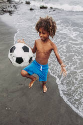 Junge spielt mit einem Fußball am Strand - LJF00986