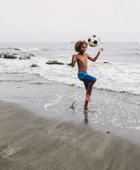 Boy playing with a football on the beach - LJF00988