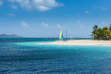 Am weißen Sandstrand vertäute Katamarane vor dem Himmel auf der Insel Palm, Grenadinen, St. Vincent und die Grenadinen, Karibik - RUNF03091