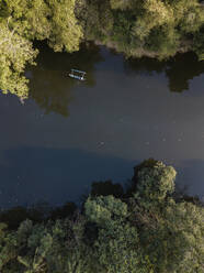 Luftaufnahme eines Bootes auf einem Fluss inmitten von Bäumen auf Bali, Indonesien - KNTF03355