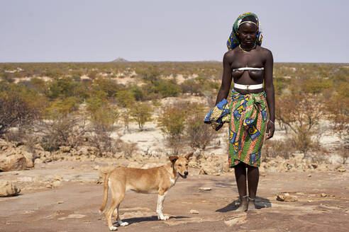 Frau vom Stamm der Mucubal und ihr Hund, Tchitundo Hulo, Virei, Angola - VEGF00614