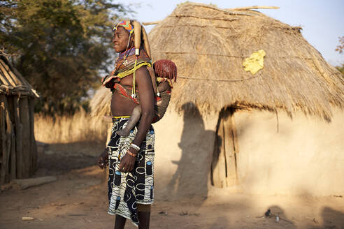 Frau vom Stamm der Muhila trägt ihr Kind auf dem Rücken, Kehamba, Chibia, Angola - VEGF00620