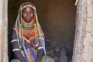 Porträt einer traditionellen Muhila-Frau, die in ihrem Haus sitzt, traditionelles Dorf Muhila, Congolo, Angola - VEGF00647