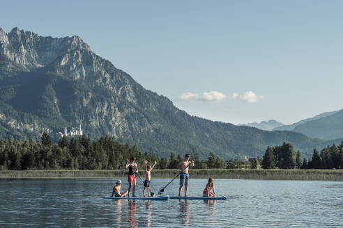 Familie mit Stand Up Paddle Boards auf einem See, Bannwaldsee, Allgäu, Bayern, Deutschland - WFF00086
