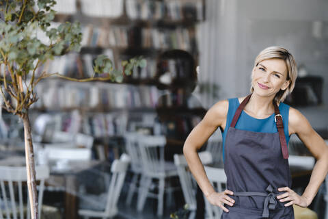 Portrait of blond woman, standing in front of her own coffee shop stock photo