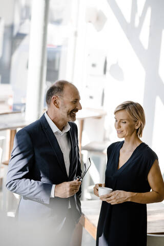 Geschäftsmann und Frau sprechen über Lösungen, trinken Kaffee, lizenzfreies Stockfoto