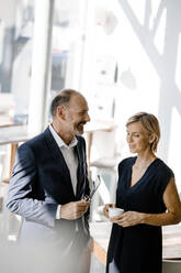 Businessman and woman talking about solutions, drinking coffee - KNSF06354