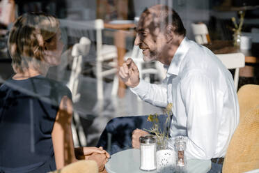 Businessman and woman having a meeting in a coffee shop - KNSF06366