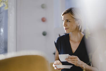 Businesswoman drinking cup of coffee - KNSF06381