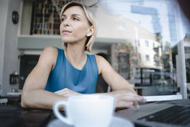 Businesswoman taking a break in coffee shop, uisng laptop - KNSF06404